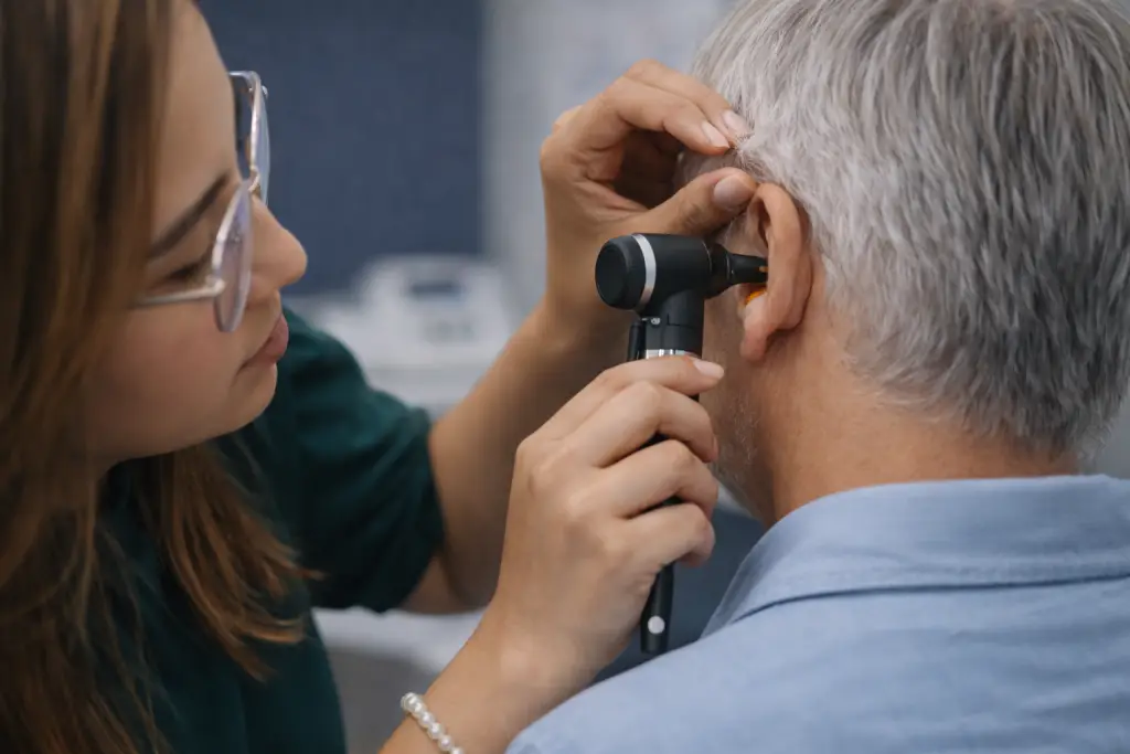 Audiologist examining a patient during an ear assessment