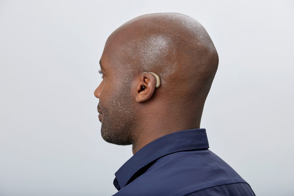 Oticon Intent hearing aid worn behind a man’s ear