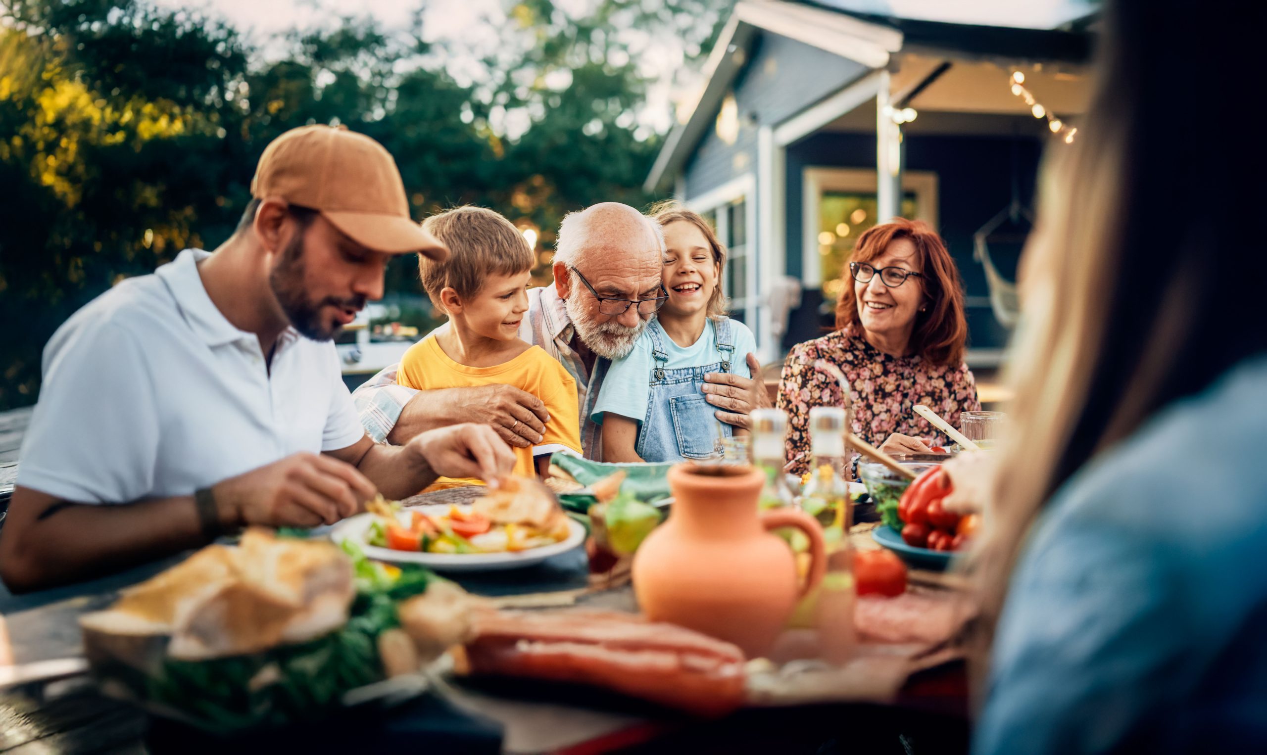 Family enjoying an outdoor dinner together with Oticon Jet PX hearing support