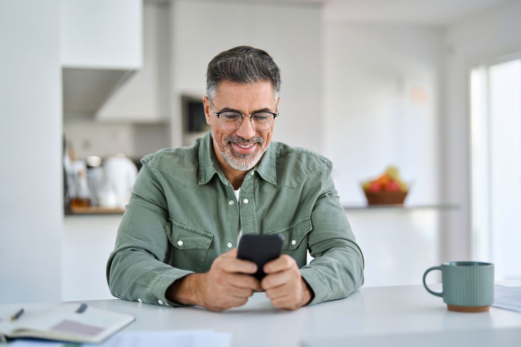 Man using a smartphone with Oticon Jet PX hearing aids