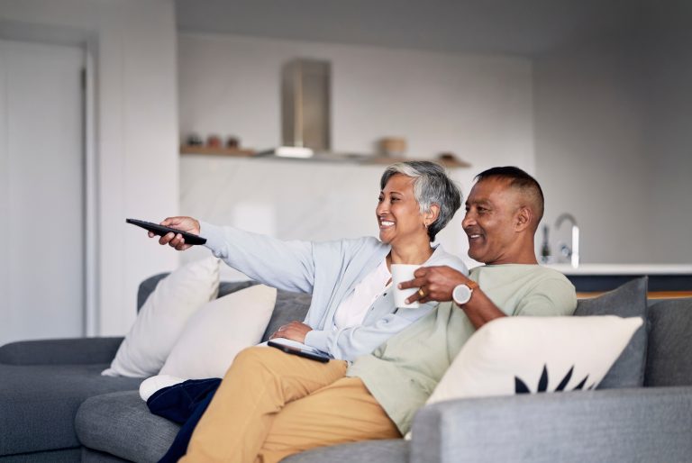 Couple watching television together at home