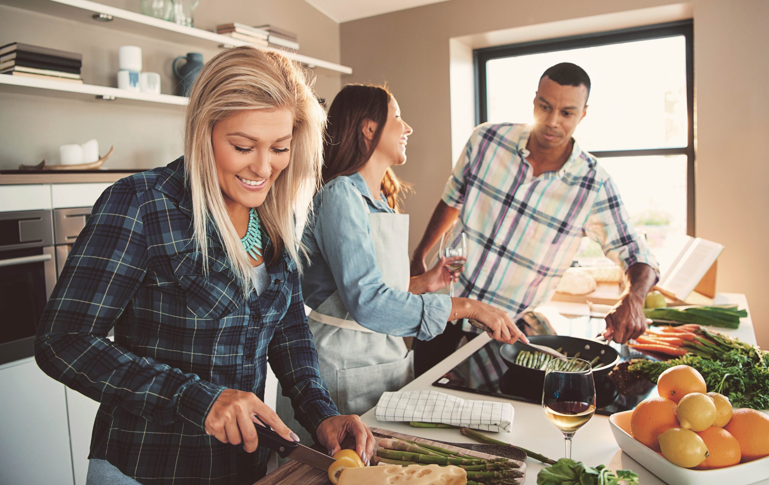 Friends cooking together while wearing discreet Oticon Own SI hearing aids