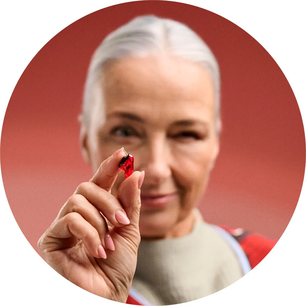 Woman holding a small Signia Insio IX custom hearing aid