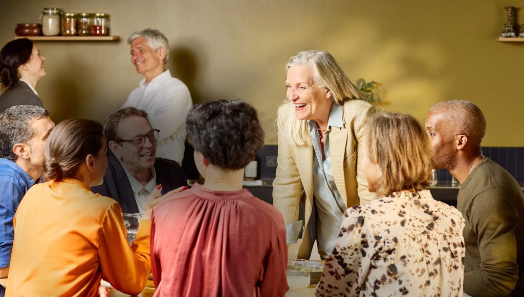 People in a busy group conversation illustrating Signia hearing aid listening situations
