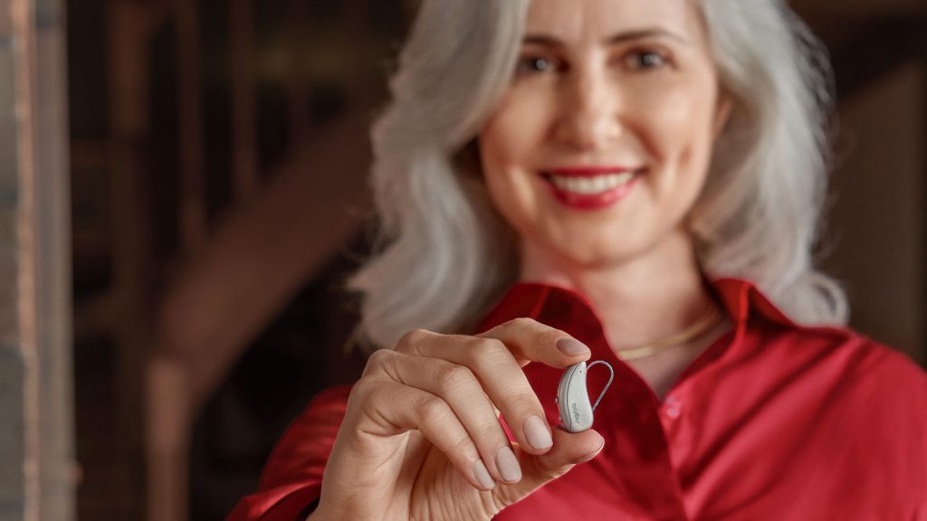 Woman holding a Signia Pure C&G MaX hearing aid