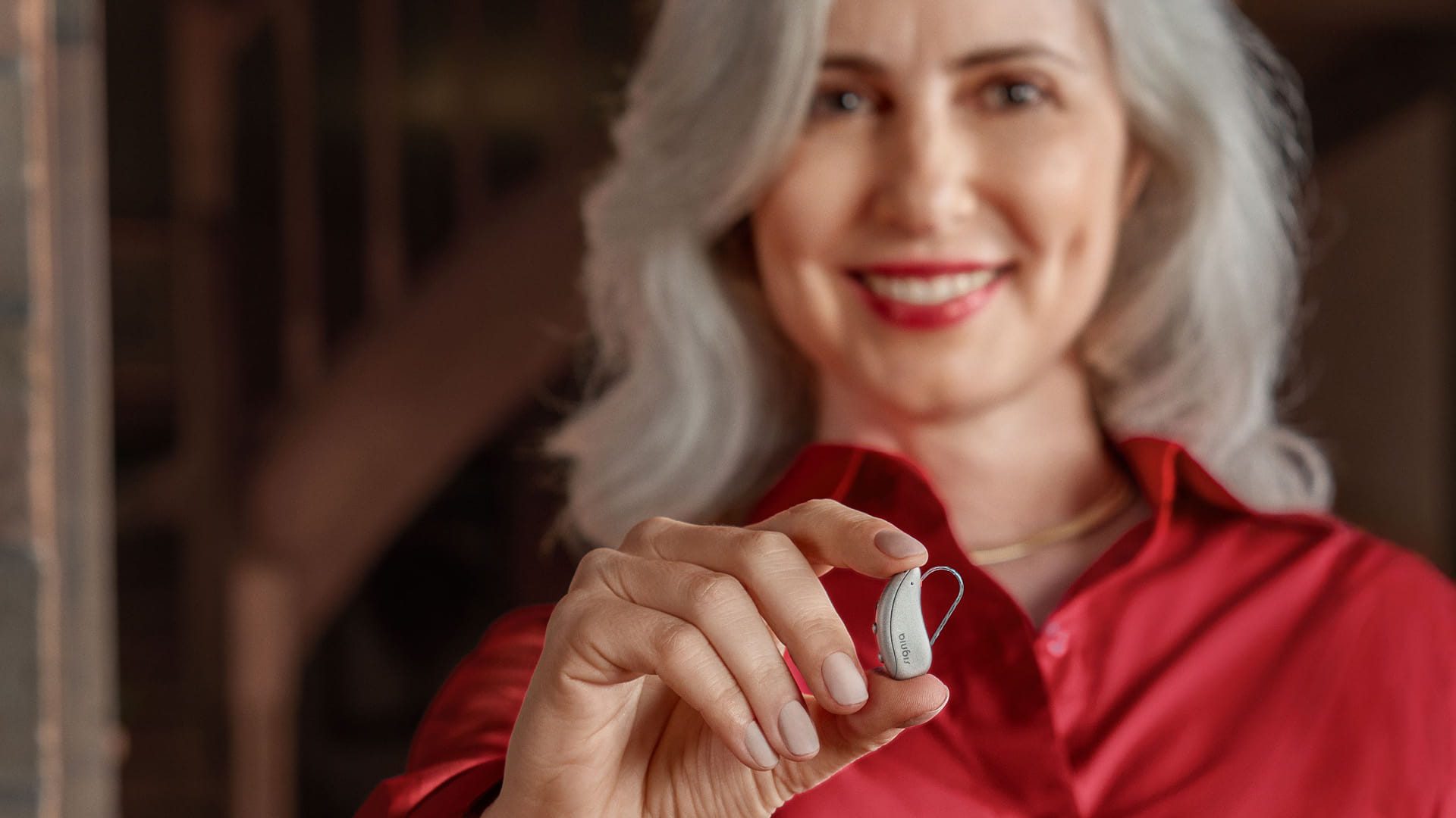 Woman holding a Signia Pure C&G MaX hearing aid